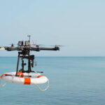 Radio control octocopter (Drone/ UAV) in the air carrying life ring to rescue active drowning victim.